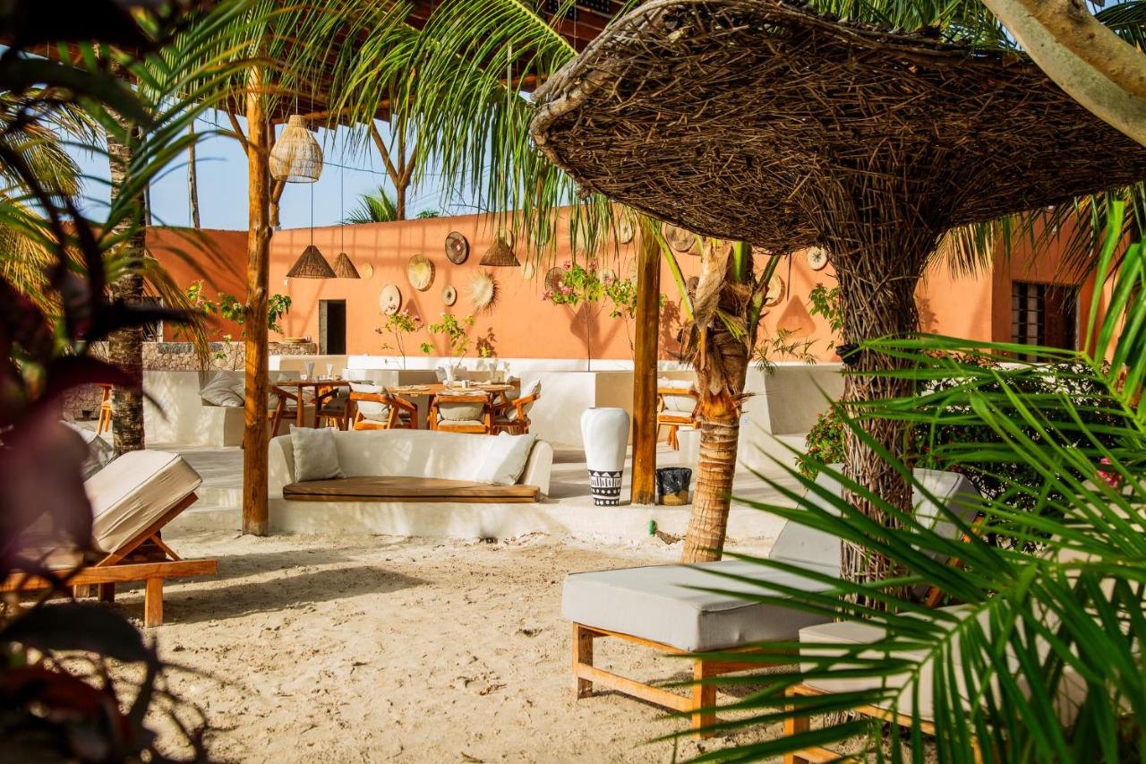 Loungers under a thatched shade on the Zanzibar beachfront